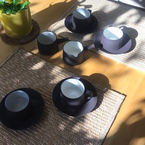 4 mugs and saucers with a sugar-and creamer set.